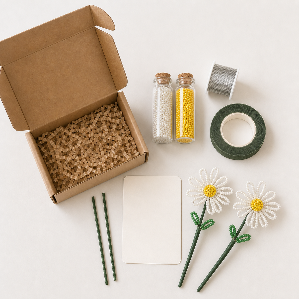 Flat lay of the DIY beaded daisy kit contents with white, yellow, and green beads
